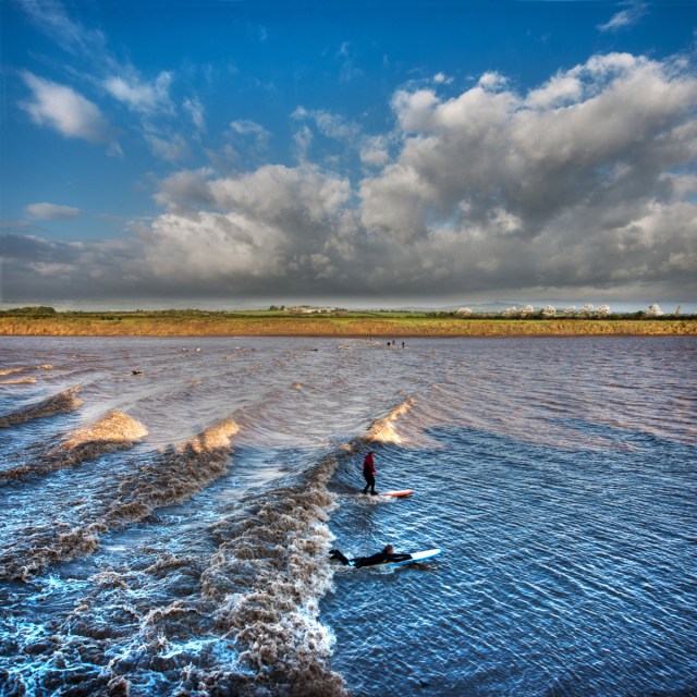 Surfers ride The Severn bore at Epney.