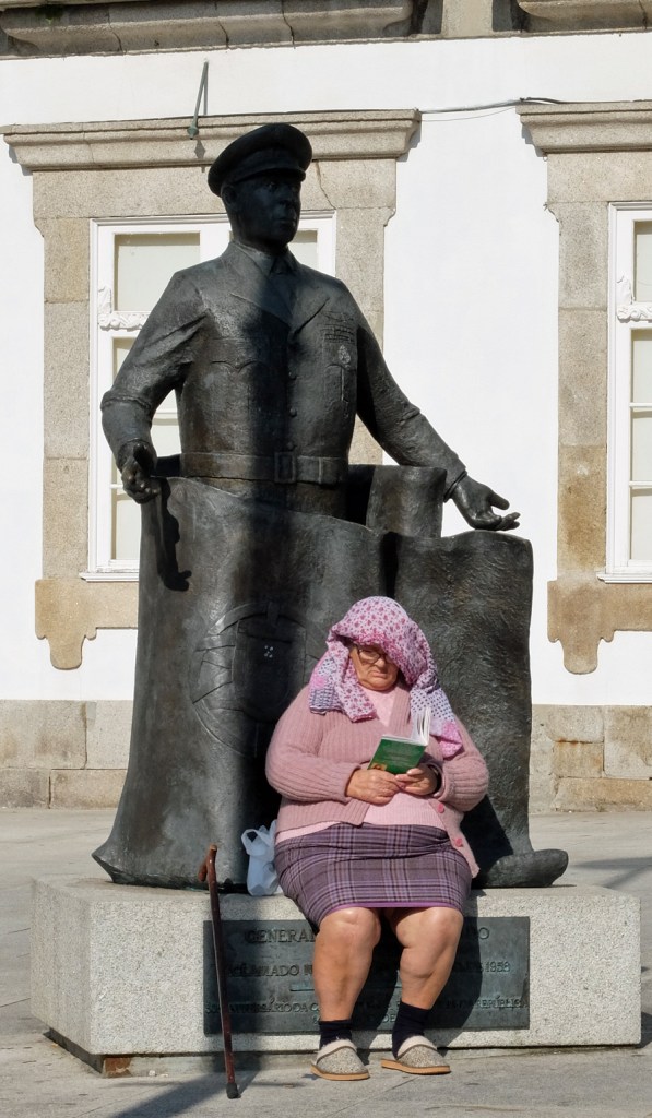 Woman reading by statue, Pç Carlos Alberto.